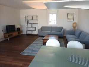 uma sala de estar com sofás azuis e uma mesa em Appartement Hendaye, 3 pièces, 6 personnes - FR-1-239-827 em Hendaye