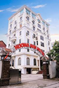 een wit gebouw met een rood bord erop bij Hương Sen Hotel Bac Giang in Bắc Giang