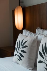 a bed with two white pillows with leaves on it at Casa Pia in Sayulita