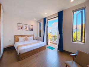 a bedroom with a bed and a large window at Dawn Villa Homestay Hội An in Hoi An