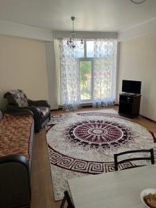 a living room with a rug on the floor at Берег in Bosteri