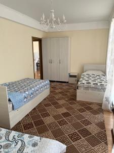 a bedroom with two beds and a chandelier at Берег in Bosteri