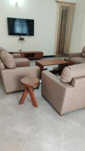 Sala de estar con 2 sofás y mesa en FAD Home & Apartments, en Dodoma
