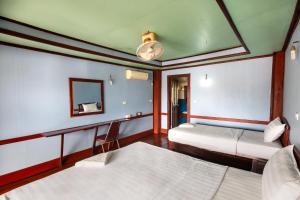 a room with two beds and a mirror at Nongsak Riverside Guesthouse & Nongsak Guesthouse in Ban Khon