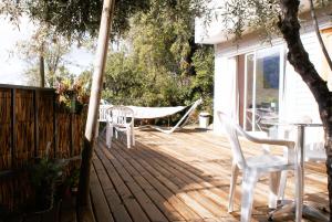 a wooden deck with a table and chairs on it at Ladera Encanto in Caleu