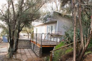 een klein wit huis met een veranda en een trap bij Ladera Encanto in Caleu