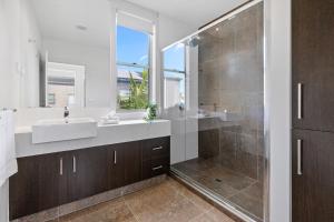 Un baño con dos lavabos y una ducha. en The Cove - Luxury Waterfront Accommodation, en Safety Beach 17 fotos más