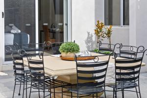 una mesa con cuatro sillas y una mesa con una planta en The Cove - Luxury Waterfront Accommodation, en Safety Beach