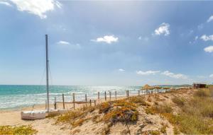 einen Sandstrand mit Sonnenschirmen und dem Meer in der Unterkunft Amazing Apartment In Marina Di Ragusa in Marina di Ragusa