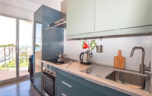 eine Küche mit einem Waschbecken und einem großen Fenster in der Unterkunft Amazing Apartment In Marina Di Ragusa in Marina di Ragusa