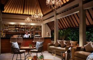 a restaurant with a bar with chandeliers at Goya Boutique Resort in Ubud