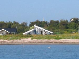 a house sitting on the shore of a body of water at 10 person holiday home in Ebeltoft in Ebeltoft