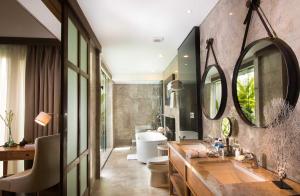 a bathroom with a sink and a toilet and a mirror at Goya Boutique Resort in Ubud