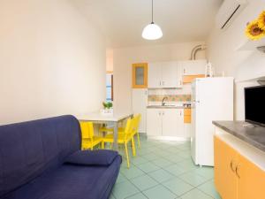 a kitchen with a couch and a table and a refrigerator at Attractive Holiday Home in Rosolina near Lungomare Beach in Rosolina