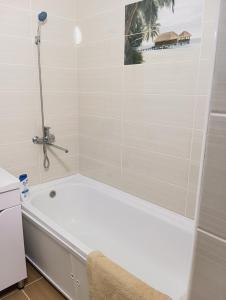 a white bath tub in a bathroom with a shower at "Kamchybek Ata" guest house B&B in Tërt-Kul'