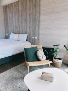 a bedroom with a bed and a chair and a table at Wei Wei Chu B&B in Zhuangwei