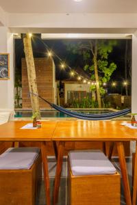 a dining room with a table and a hammock at Twiny's in Kuta Lombok