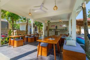 a patio with tables and chairs and a restaurant at Twiny's in Kuta Lombok