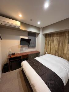 um quarto com uma cama e uma televisão de ecrã plano em HOTEL ERENOA em Nagoia