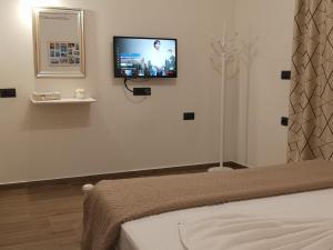 a bedroom with a tv on a wall with a bed at SUNNY HOLIDAYS APARTMENT in Kremasti