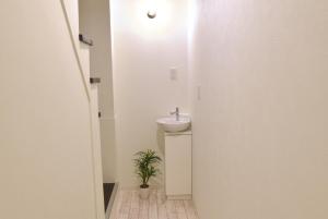 a bathroom with a sink and a potted plant at Ogu house Beppu in Beppu