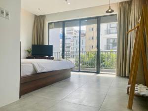 a bedroom with a bed and a large window at Light House Hostel in Danang