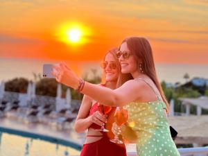 Due donne che si fanno una foto con dei bicchieri da vino di Paradiso Terme Resort & SPA con 5 piscine termali a Ischia