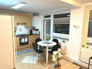 a kitchen with a table and chairs in a room at FW Haute Apartments at Tottenham Hale, 4 Bedroom and 2 Bathroom Pet-Friendly Duplex Flat, King or Twin beds with FREE WIFI and PARKING in London