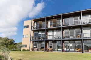an apartment building with balconies and tables at Fairway Views – Moonah Apartment 23 in Fingal