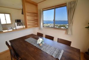 a dining room with a table and a large window at Bep one the house with ocean view in Kamegawa