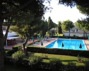 uma grande piscina num parque com árvores em Marina di Bibbona - Lotto B em Marina di Bibbona