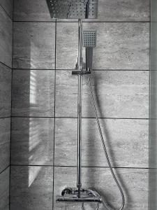 a shower with a blow dryer on a wall at Sparkling Space - Twin or King Beds in Bangor