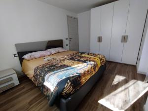 Casa vacanze Caspoggio في كاسبوجيو: غرفة نوم بسرير كبير ودواليب بيضاء