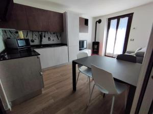 Casa vacanze Caspoggio في كاسبوجيو: مطبخ وغرفة طعام مع طاولة وكراسي