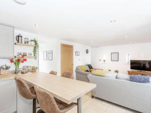 a kitchen and living room with a table and a couch at Pogles Wood Cottage in Skipton