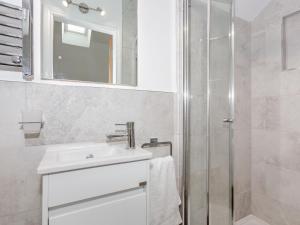 a white bathroom with a sink and a shower at Pogles Wood Cottage in Skipton +14 photos