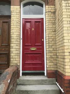 a red door on the side of a brick building at Sparkling Space - Twin or King Beds in Bangor
