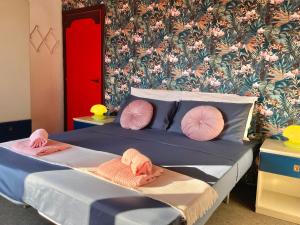 1 dormitorio con cama con almohadas rosas y papel pintado en Villetta sul mare, en Francavilla al Mare