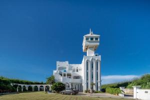 a white building with a clock tower on top of it at 夏日澄藍The Charming Land in Baisha