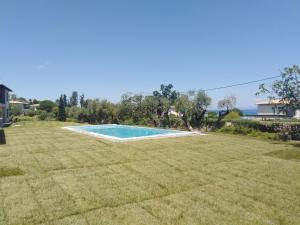 a swimming pool in the middle of a grass field at B A Seaside Villa private pool in Pefkochori