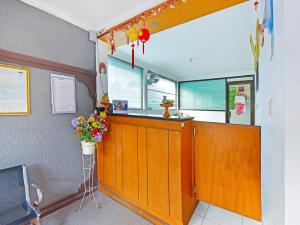 a restaurant with a counter with flowers on the wall at Capital O 91406 Agus Jaya Residence in Denpasar