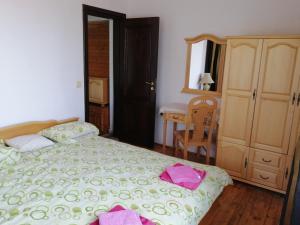 a bedroom with a bed with pink towels on it at Elida Guest House in Shabla