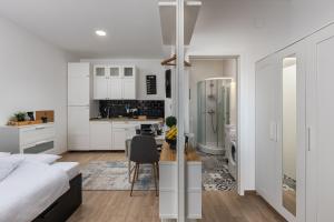 a bedroom with a bed and a table and a kitchen at Agostini Residence - SELF CHECK-IN ONLY in Rijeka