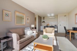 a living room with a couch and a table at Fairway Views – Moonah Apartment 24 in Fingal