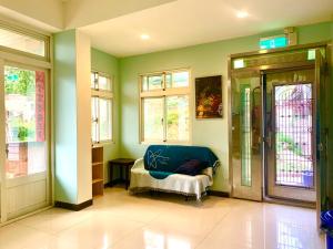 een kamer met een blauwe bank in een kamer met ramen bij Myhome Homestay in Nangan