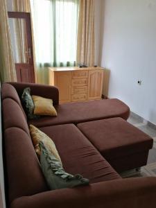 ein Wohnzimmer mit einem braunen Sofa und einer Kommode in der Unterkunft Elida Guest House in Shabla