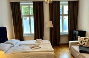 ウィーンにあるCasa Nostra - Zentrale Wohnung am Augartenのベッドルーム1室(ベッド1台、ソファ、窓付)