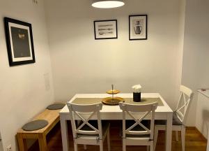 uma sala de jantar com uma mesa branca e cadeiras em Casa Nostra - Zentrale Wohnung am Augarten em Viena