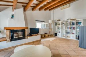 a living room with a fireplace and a table at Casa Agnès in Mahón