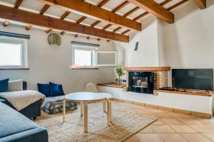 sala de estar con sofá, TV y chimenea en Casa Agnès en Mahón